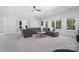 Spacious living room with gray sofas, large windows, carpet flooring, and white trim at 5001 Oxfordshire Rd, Waxhaw, NC 28173