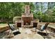 Outdoor fireplace offers a cozy spot for relaxing near the spa, with two outdoor chairs at 5001 Oxfordshire Rd, Waxhaw, NC 28173
