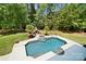 Aerial view of a backyard pool with an attached jacuzzi, fireplace, and lush landscaping at 5001 Oxfordshire Rd, Waxhaw, NC 28173