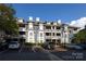 Apartment building with a parking lot featuring allocated parking spaces and manicured shrubs at the building's base at 501 Olmsted Park Pl # N, Charlotte, NC 28203