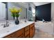 Bathroom featuring double sinks, soaking tub, and cherry wood cabinets at 5127 Fernhill Dr, Charlotte, NC 28217