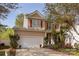 Charming two-story home with a well-maintained lawn, two-car garage and colorful landscaping in the front at 5127 Fernhill Dr, Charlotte, NC 28217