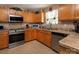 Cozy kitchen features stainless steel appliances, light wood cabinets and tile floors at 5127 Fernhill Dr, Charlotte, NC 28217