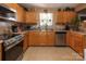 Functional kitchen featuring natural wood cabinetry, stainless steel appliances, and a tile floor at 5127 Fernhill Dr, Charlotte, NC 28217
