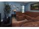 Living room features plush brown furniture and a large picture window at 5127 Fernhill Dr, Charlotte, NC 28217