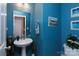 Charming powder room is painted with blue walls and has pedestal sink at 5127 Fernhill Dr, Charlotte, NC 28217
