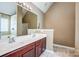 Bathroom features a double vanity with cherry wood cabinets, two sinks, and a tub/shower combo at 5713 Falkirk Ln, Matthews, NC 28104