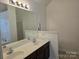 Bathroom featuring a double sink vanity with a large mirror and decorative lighting at 5713 Falkirk Ln, Matthews, NC 28104