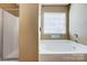Bathroom featuring a bathtub, walk-in shower, and window, providing a bright and functional space at 5713 Falkirk Ln, Matthews, NC 28104