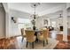 Open dining area with hardwood floors, chandelier, and seamless transition to the adjacent living room at 5713 Falkirk Ln, Matthews, NC 28104