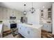 Modern kitchen with gray cabinets, stainless steel appliances, large island, and decorative pendant lights at 5713 Falkirk Ln, Matthews, NC 28104