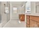Bright bathroom featuring a double vanity with wood cabinets and a tiled walk-in shower with glass door at 5850 Strathmore Ct, Charlotte, NC 28215