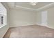 Bedroom featuring neutral carpet, natural light, and a tray ceiling at 5850 Strathmore Ct, Charlotte, NC 28215