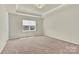 Bedroom showcasing neutral walls, neutral carpet, and a tray ceiling at 5850 Strathmore Ct, Charlotte, NC 28215