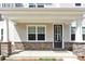 Inviting front porch with stone-clad pillars and black door creating a welcoming entrance to the home at 5850 Strathmore Ct, Charlotte, NC 28215