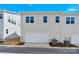 Back exterior showcasing garage doors, tidy landscaping, and the building's clean lines beneath a clear blue sky at 5850 Strathmore Ct, Charlotte, NC 28215
