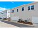 Rear view of garages and outdoor air conditioning units for multiple townhomes; blue sky is visible at 5850 Strathmore Ct, Charlotte, NC 28215