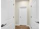 Hallway featuring wood-look floors and white doors with black hardware at 5850 Strathmore Ct, Charlotte, NC 28215