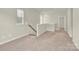 Hallway showcasing neutral walls, railing with wood handrail, and neutral carpet at 5850 Strathmore Ct, Charlotte, NC 28215