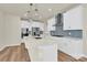 Bright kitchen with white cabinets, modern appliances, island with pendant lights, and stylish backsplash at 5850 Strathmore Ct, Charlotte, NC 28215