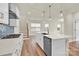 Modern kitchen with a large island, stainless steel appliances, and hardwood flooring, flooded with natural light at 5850 Strathmore Ct, Charlotte, NC 28215
