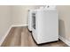 Side view of the white washer and dryer, in the laundry room with wood floors at 5850 Strathmore Ct, Charlotte, NC 28215