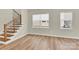 Living space featuring wood-look floors, a modern staircase, and natural light at 5850 Strathmore Ct, Charlotte, NC 28215