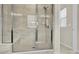 Modern tiled walk-in shower with a built-in bench and sleek glass enclosure at 5850 Strathmore Ct, Charlotte, NC 28215