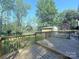 Inviting wooden back deck overlooking a lush, green backyard and storage building at 6430 Farmingdale Dr, Charlotte, NC 28212