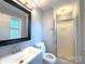 Bathroom featuring a framed mirror, vanity, toilet, and shower with glass doors at 6430 Farmingdale Dr, Charlotte, NC 28212
