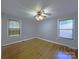 A well-lit bedroom with hardwood floors, two windows, and a ceiling fan at 6430 Farmingdale Dr, Charlotte, NC 28212