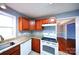 Cozy kitchen featuring granite countertops, white appliances, and wood cabinets at 6430 Farmingdale Dr, Charlotte, NC 28212