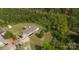 Aerial view of the home and surrounding wooded landscape on a sunny day at 6599 Mcintosh Rd, Stanley, NC 28164