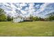 View of the home's backyard featuring a deck and spacious lawn at 6599 Mcintosh Rd, Stanley, NC 28164