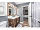 This bathroom features hardwood floors, gray walls, a toilet, and a wooden sink at 6599 Mcintosh Rd, Stanley, NC 28164