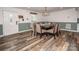 Dining room with modern wood table, chair seating, wainscotting and front door at 6599 Mcintosh Rd, Stanley, NC 28164