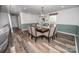 Dining room with modern wood table, chair seating, wainscotting and open living area at 6599 Mcintosh Rd, Stanley, NC 28164