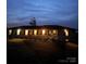 Twilight view of the home's front exterior with porch and illuminated windows at 6599 Mcintosh Rd, Stanley, NC 28164