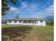 Inviting single story home featuring a white painted brick exterior, dark shutters, and a cozy front porch at 6599 Mcintosh Rd, Stanley, NC 28164