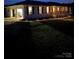 Charming home exterior at twilight featuring landscape lighting and an attached garage at 6599 Mcintosh Rd, Stanley, NC 28164