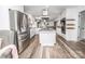 Bright open kitchen featuring stainless steel appliances, island, and wood-look flooring at 6599 Mcintosh Rd, Stanley, NC 28164