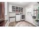 This laundry room features hardwood floors, white walls, built-in cabinets, and a washer and dryer at 6599 Mcintosh Rd, Stanley, NC 28164