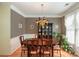 Dining room with classic wallpaper, hardwood floors, and a dark wood china cabinet, adjacent to a bright window at 6615 Wickville Dr, Charlotte, NC 28215