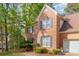 Two-story brick home featuring blue shutters and a well-manicured lawn with a walkway leading to the front door at 6615 Wickville Dr, Charlotte, NC 28215