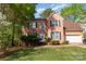 Charming brick two-story home featuring a well-maintained front yard with mature trees, and attached two car garage at 6615 Wickville Dr, Charlotte, NC 28215