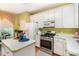 Functional kitchen featuring white cabinets, laminate countertops, a gas range, and a cozy dining area at 6615 Wickville Dr, Charlotte, NC 28215