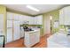 Bright kitchen with white cabinets, hardwood floors, and a center island at 6615 Wickville Dr, Charlotte, NC 28215