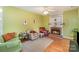 Cozy living room with a brick fireplace, hardwood floors, comfortable seating, and bright green walls at 6615 Wickville Dr, Charlotte, NC 28215