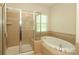 Bathroom featuring a tiled walk-in shower and a luxurious soaking tub at 729 Naramore St, Davidson, NC 28036