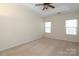 Neutral carpeted bedroom with tray ceiling, ceiling fan and bright natural light at 729 Naramore St, Davidson, NC 28036